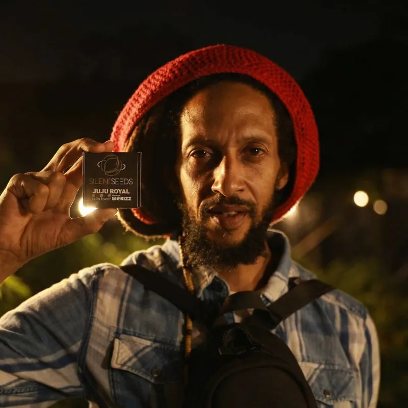 Jamaican Sunset Produktfoto Mann mit roter Mütze hält eine Packung Jamaican Sunset Samen in der Hand